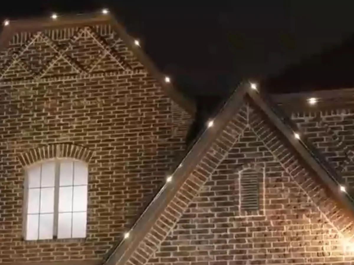 A brick home with an evenly white run of lights from end to end